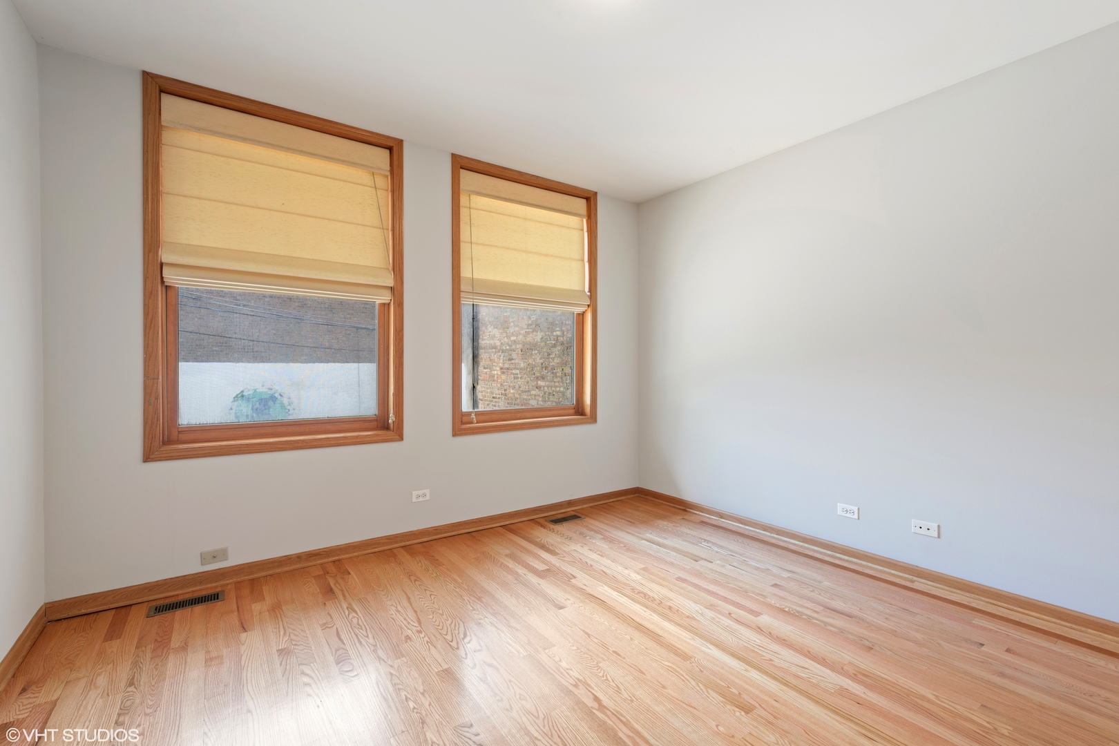 927 North Noble Street, Unit 1 Chicago, IL 60642 - Photo 5 of 10 an empty room with wooden floor and windows