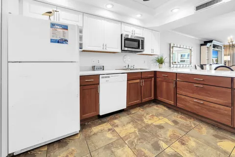 a kitchen with stainless steel appliances granite countertop a refrigerator and a stove top oven