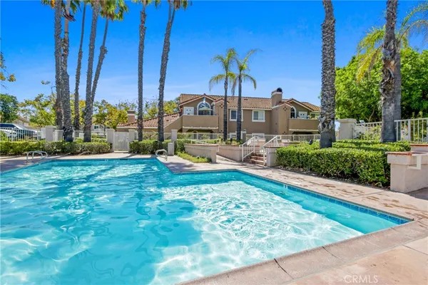 a view of swimming pool with lawn chairs and plants