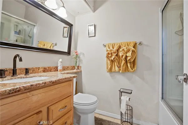 a bathroom with a granite countertop sink mirror vanity and toilet