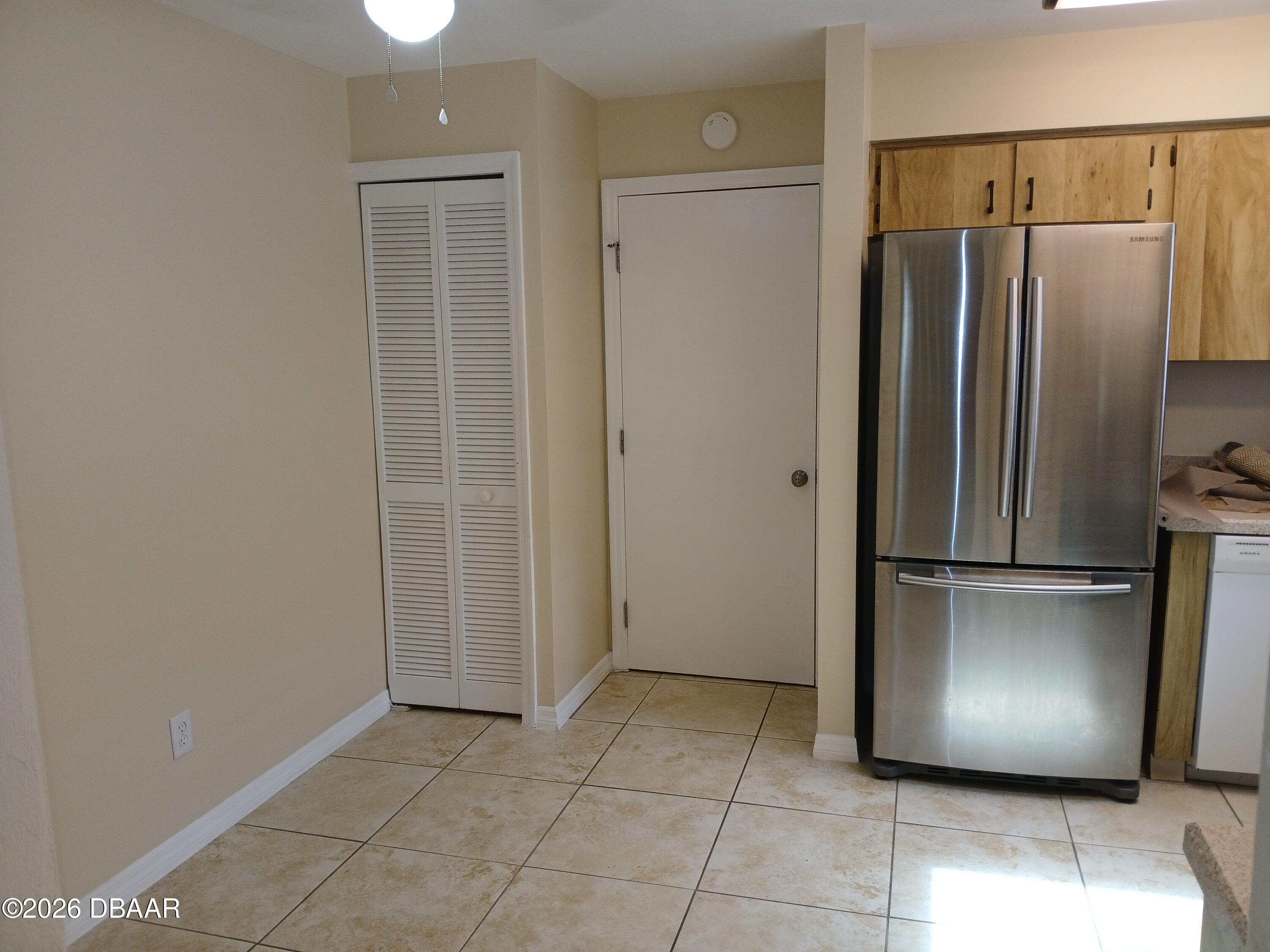 4514 Alder Drive Port Orange, FL 32127 - Photo 5 of 15 a kitchen with a refrigerator and white cabinets
