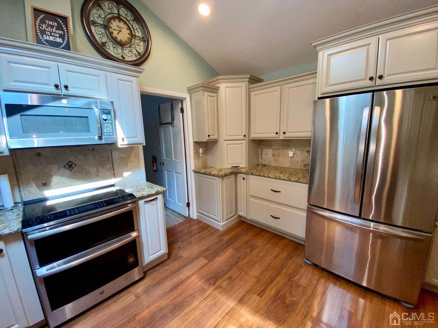 30 Woodland Road Franklin, NJ 07416 - Photo 17 of 34 a kitchen with wooden floors and stainless steel appliances