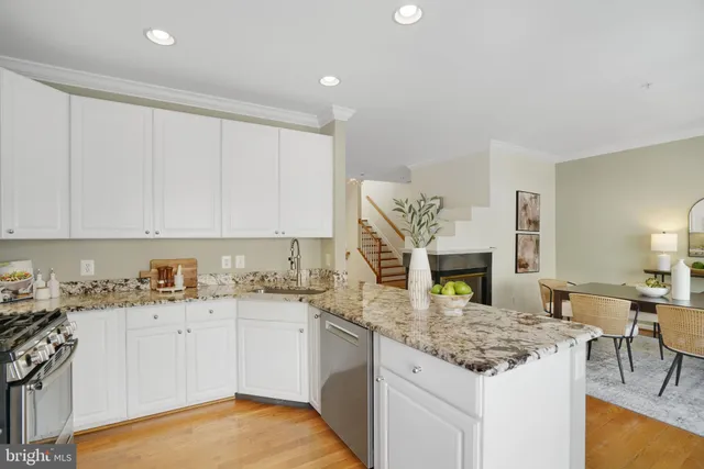 a kitchen with a table chairs stove and white cabinets