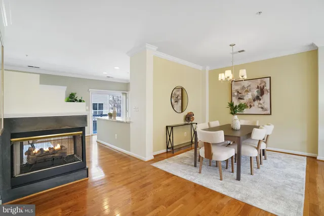 a kitchen with stainless steel appliances granite countertop a refrigerator a stove a sink a microwave a refrigerator and white cabinets with wooden floor