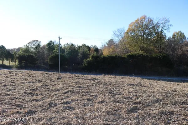 a view of dirt road with a building in the background