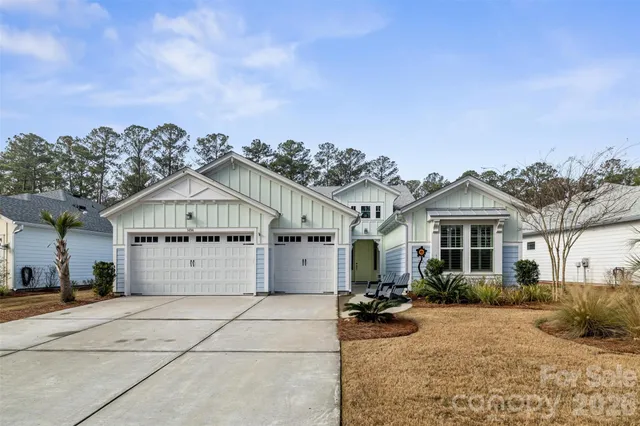 a view of a grey house with a outdoor space