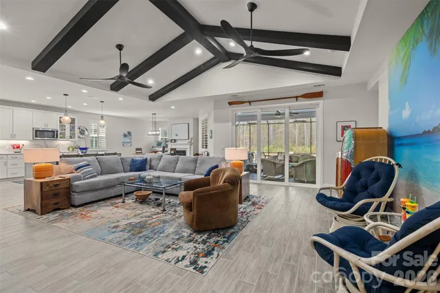 a living room with furniture a wooden floor and ceiling fan