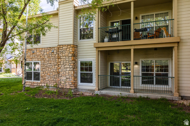 900 Bitner Road, Unit M 17 Park City, UT 84098 - Photo 21 of 29 Rear view of house with stone siding, a balcony, and a yard