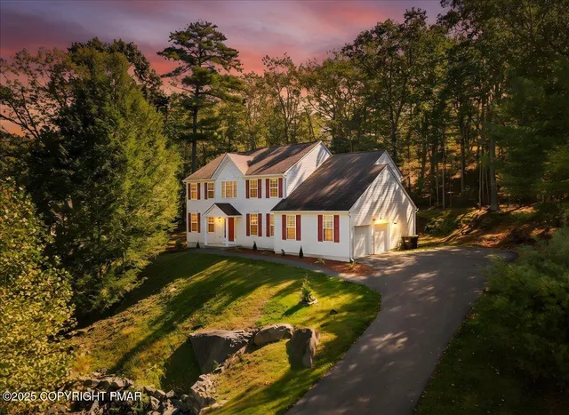 a view of a big house with large trees and plants
