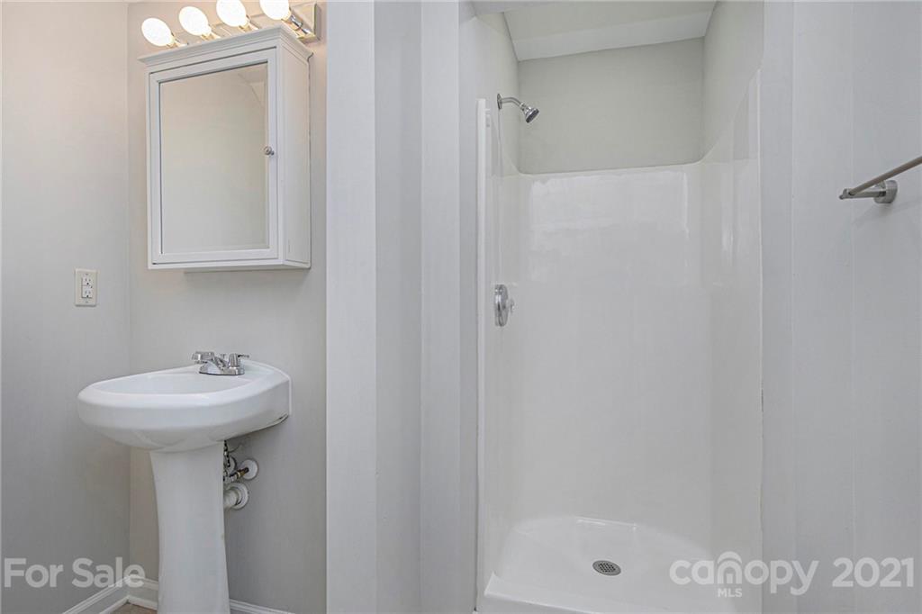 9230 Washam Potts Road Cornelius, NC 28031 - Photo 12 of 31 a bathroom with a sink a mirror and a shower