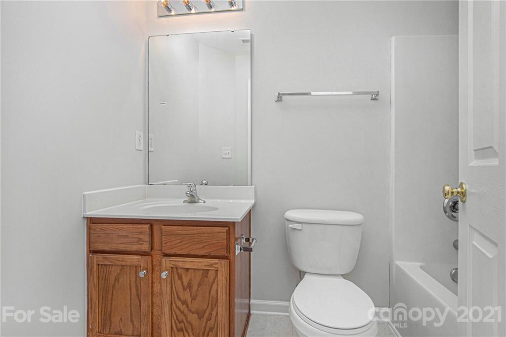 9230 Washam Potts Road Cornelius, NC 28031 - Photo 22 of 31 a bathroom with a toilet a sink and mirror