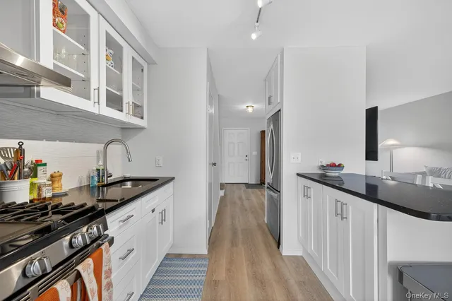a kitchen with granite countertop a sink stove and cabinets