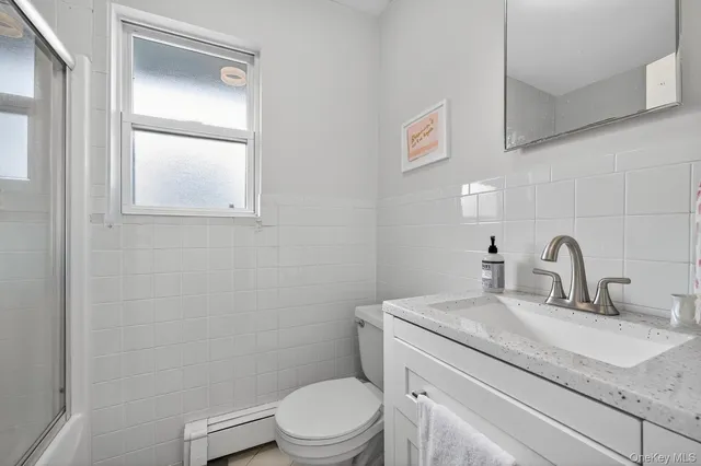 a bathroom with a granite countertop toilet sink and mirror