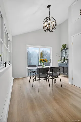 a view of a dining room with furniture a chandelier and wooden floor