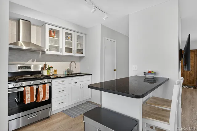 a kitchen with stainless steel appliances granite countertop a stove a sink and a refrigerator