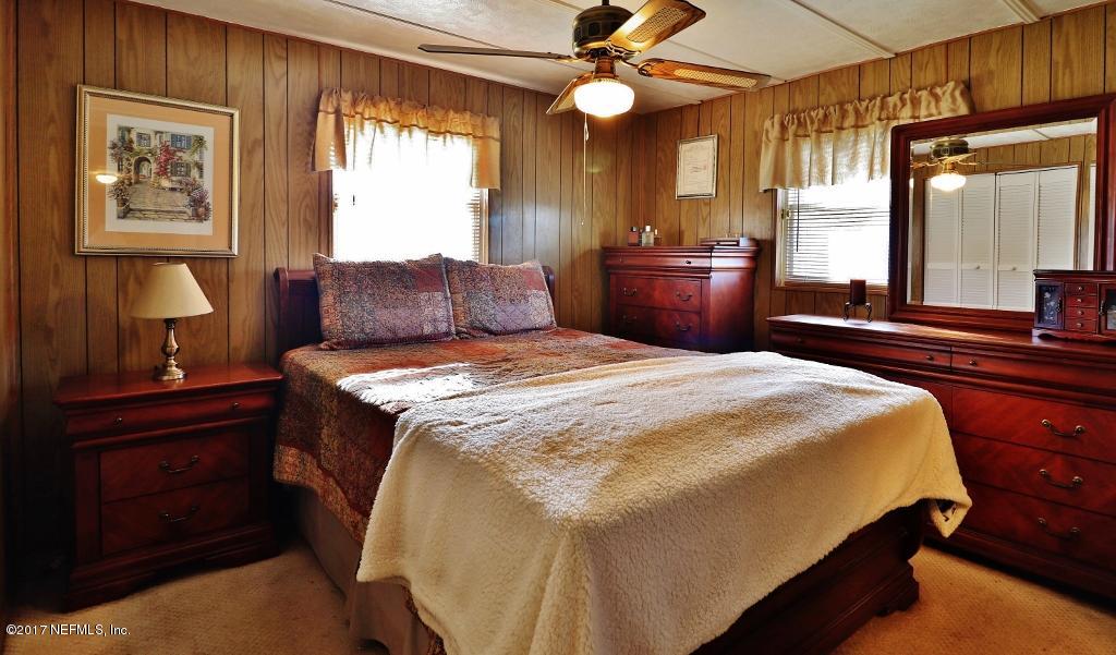 10414 Stone Road Jacksonville, FL 32246 - Photo 12 of 23 a bedroom with a large bed and a chandelier