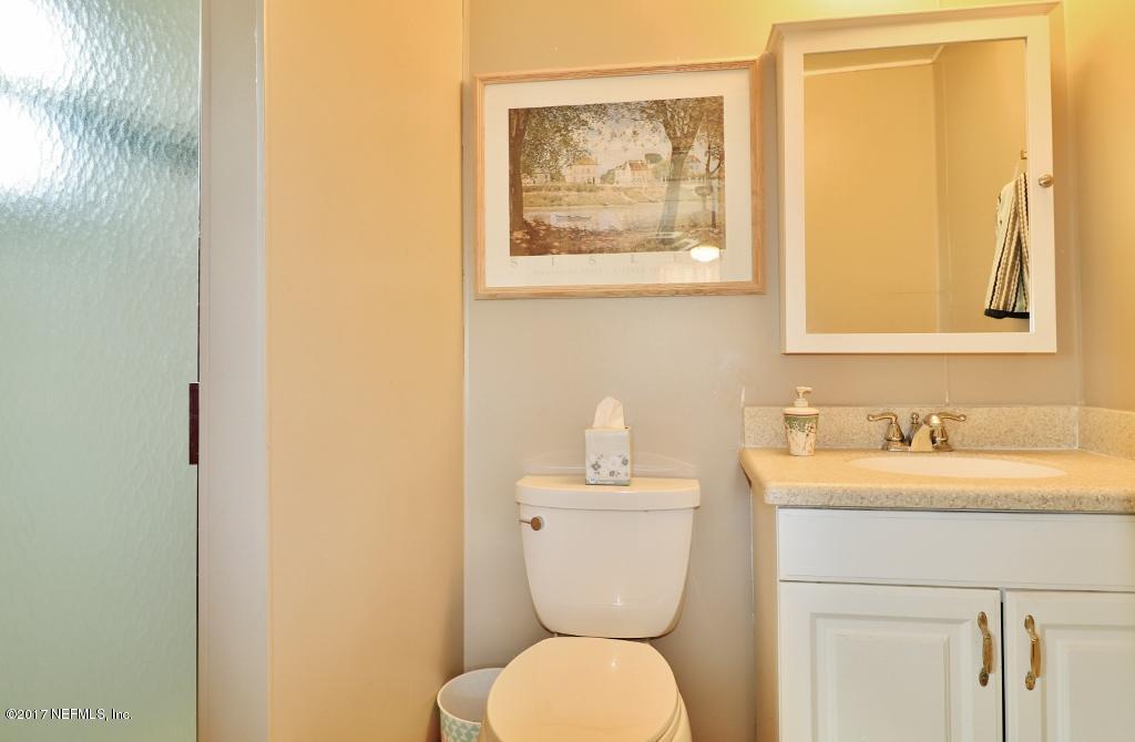 10414 Stone Road Jacksonville, FL 32246 - Photo 13 of 23 a bathroom with a toilet a sink and mirror