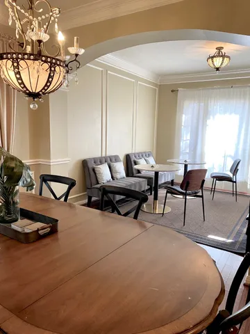 a living room with furniture a chandelier and a large window