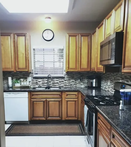 a kitchen with stainless steel appliances granite countertop a stove a sink and a granite counter tops