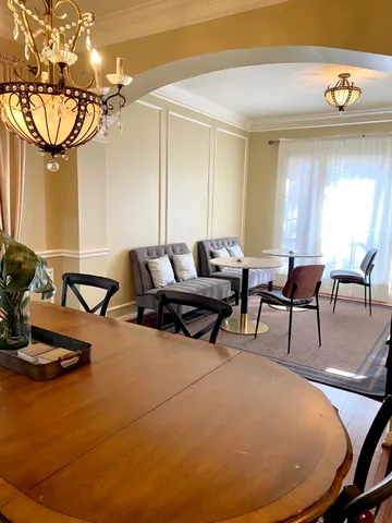 a living room with furniture a chandelier and a large window