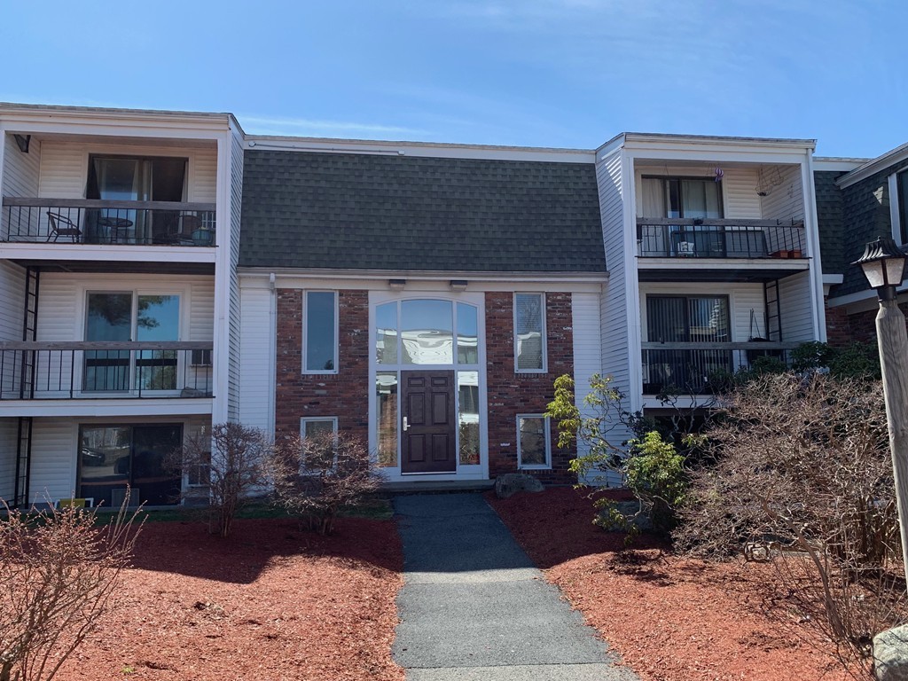 a front view of a house with yard and trees