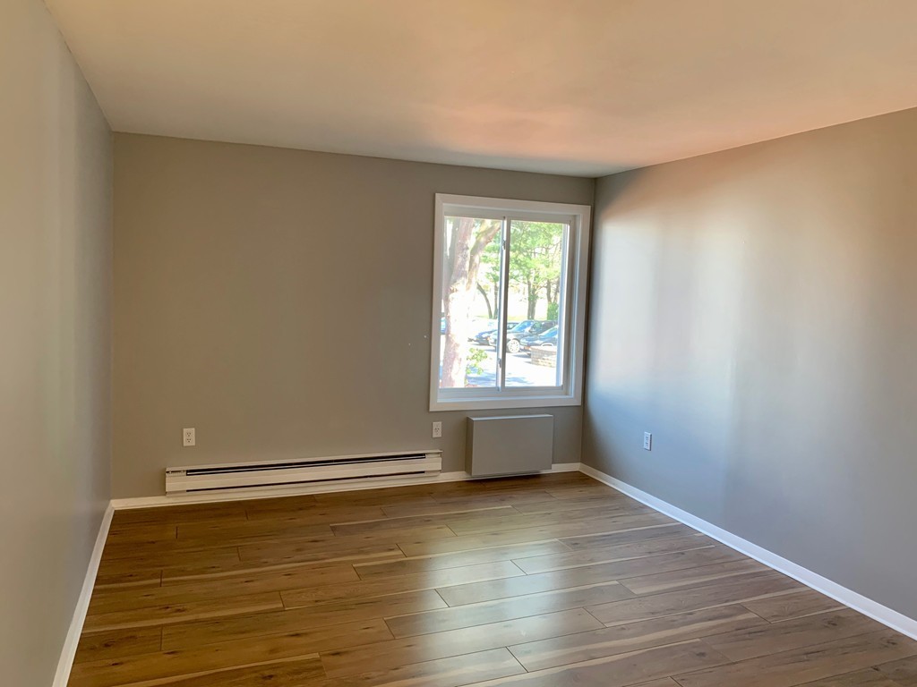 96 Main Street, Unit C4 Foxboro, MA 02035 - Photo 9 of 14 an empty room with wooden floor and windows