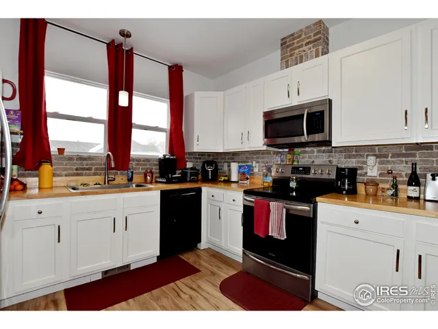 a kitchen with stainless steel appliances granite countertop a stove a sink and white cabinets