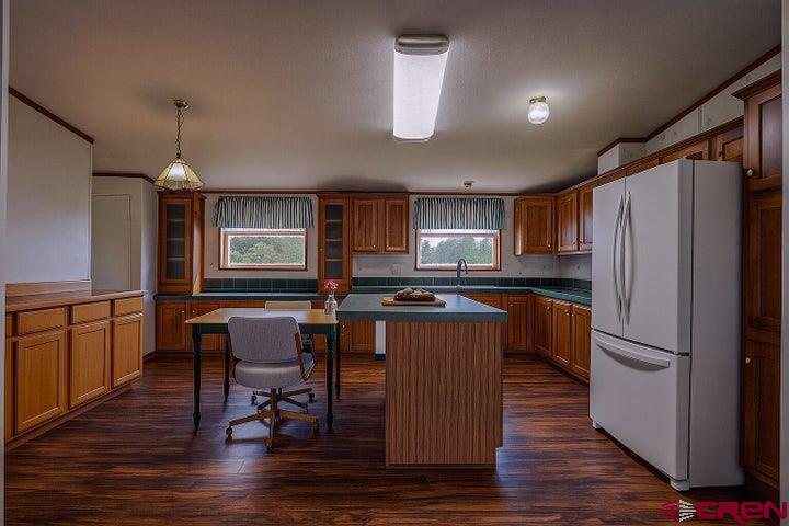 24900 Hilltop Road Trinidad, CO 81082 - Photo 7 of 17 a kitchen with stainless steel appliances granite countertop a refrigerator a sink dishwasher a stove and a dining table with wooden floor