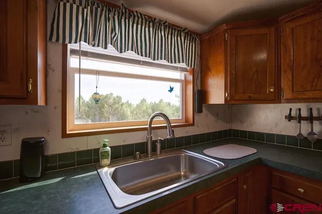 a kitchen with a sink cabinets and a window