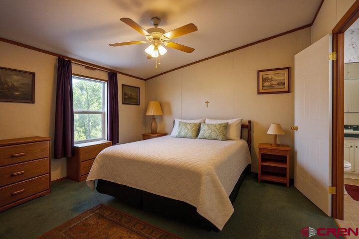 24900 Hilltop Road Trinidad, CO 81082 - Photo 10 of 17 a bedroom with a bed and a chandelier