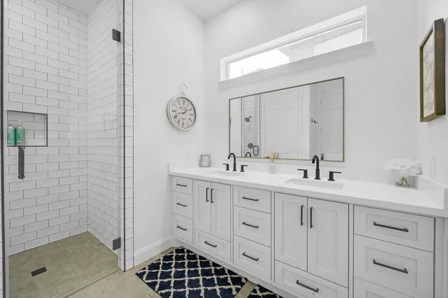a spacious bathroom with a shower a sink and a mirror