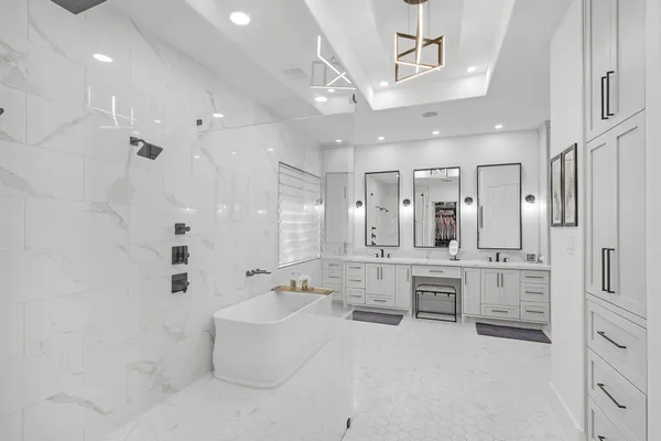 a large white bathroom with a granite countertop sink mirror and bathtub