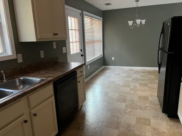 a kitchen with granite countertop a sink stove and refrigerator