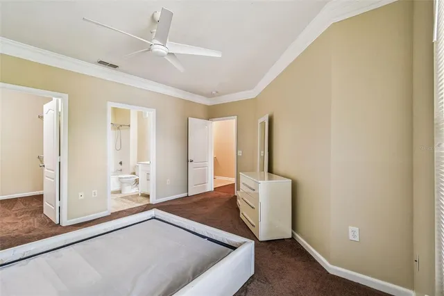 an empty room with closet and a chandelier fan