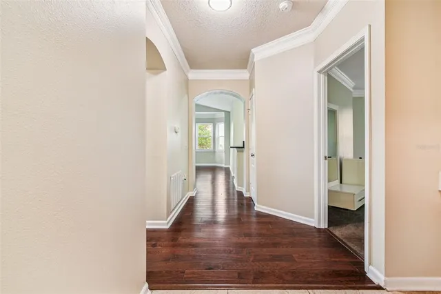 a view of an empty room with wooden floor fireplace and a window