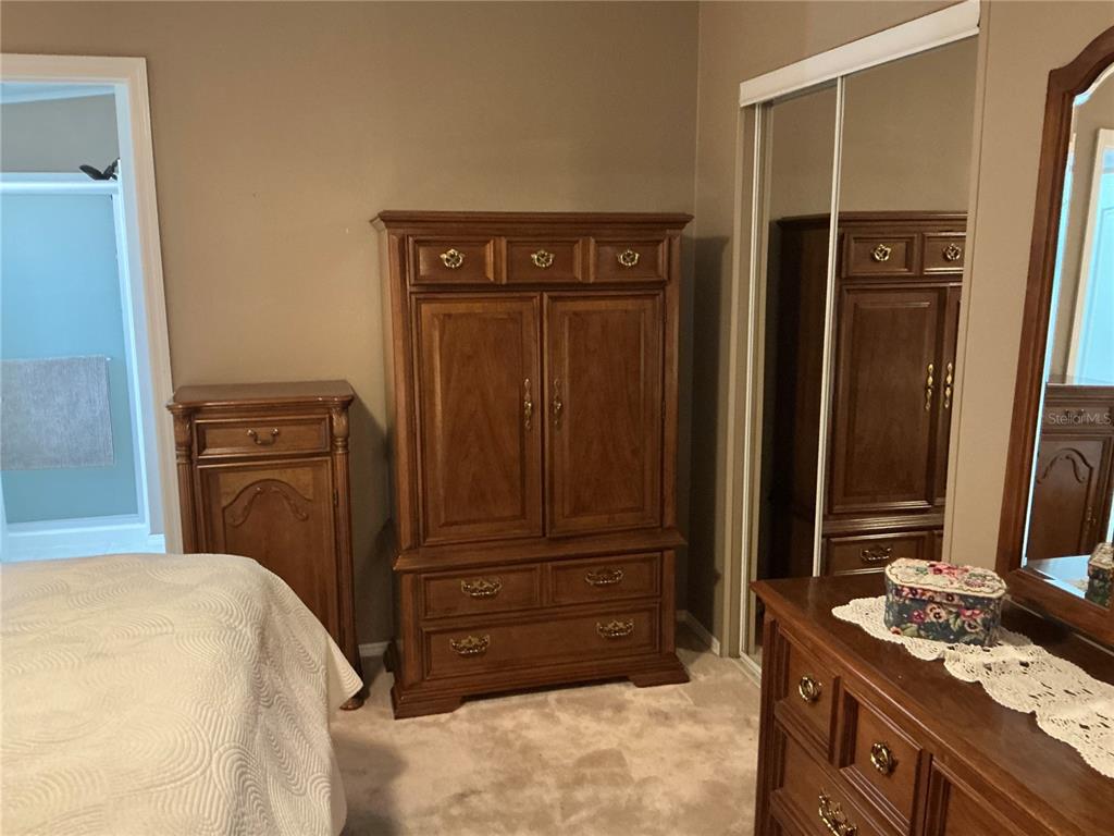 236 Allies Pass, Unit 363 Frostproof, FL 33843 - Photo 30 of 51 a bedroom with a bed and a dresser