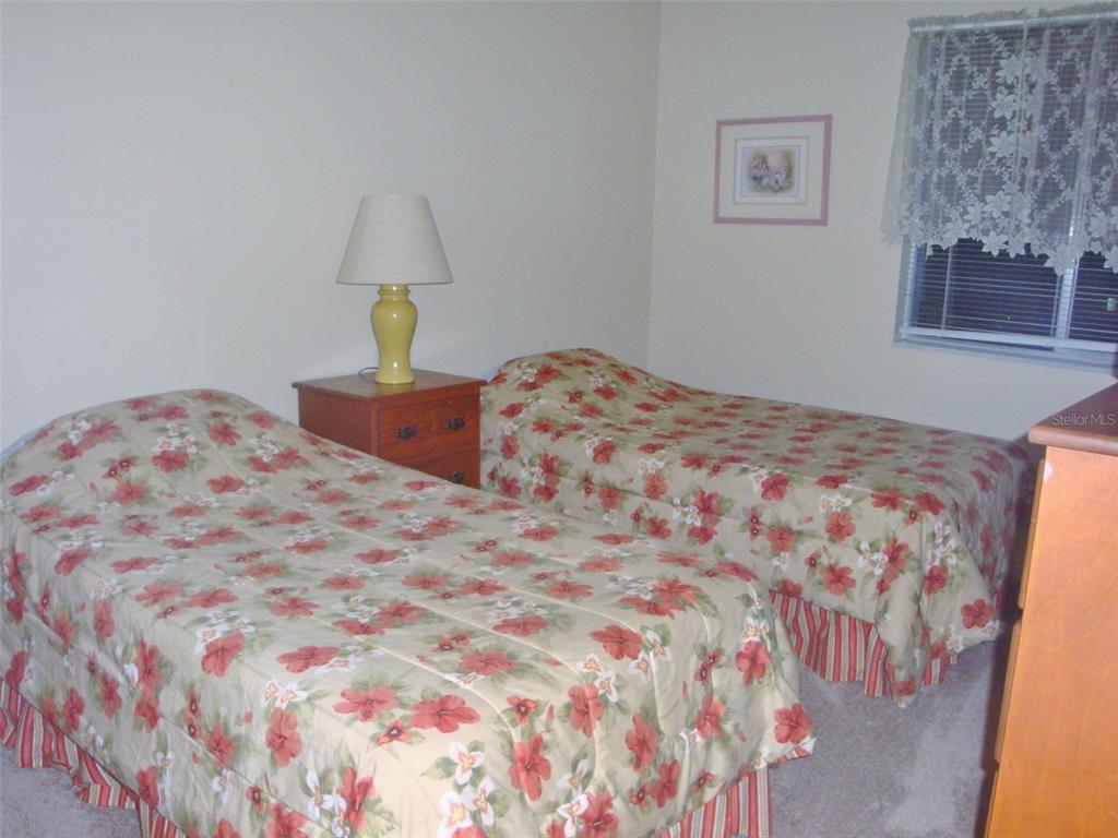 244 Cypress Lane, Unit 244 Oldsmar, FL 34677 - Photo 12 of 16 a bedroom with a bed and a lamp on dresser