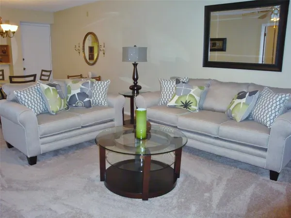 a living room with furniture and a mirror