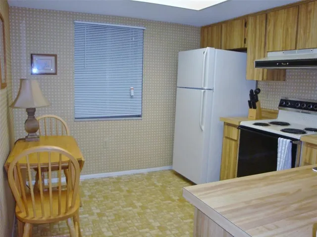 a kitchen with stainless steel appliances granite countertop a refrigerator a stove a sink dishwasher and a refrigerator