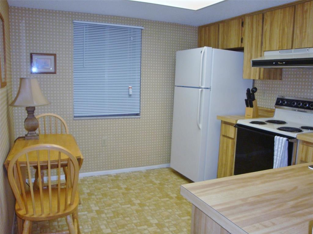 244 Cypress Lane, Unit 244 Oldsmar, FL 34677 - Photo 7 of 16 a kitchen with stainless steel appliances granite countertop a refrigerator a stove a sink dishwasher and a refrigerator