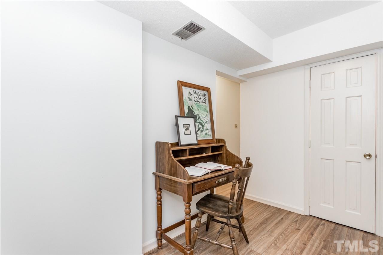 2880 Wycliff Road Raleigh, NC 27607 - Photo 17 of 23 a room with a bench and wooden floor