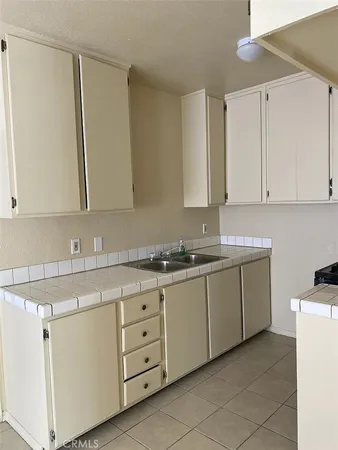 a kitchen with granite countertop white cabinets and white appliances