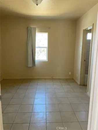 a view of a livingroom with an empty space and a window