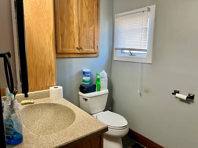 a bathroom with a granite countertop toilet and sink