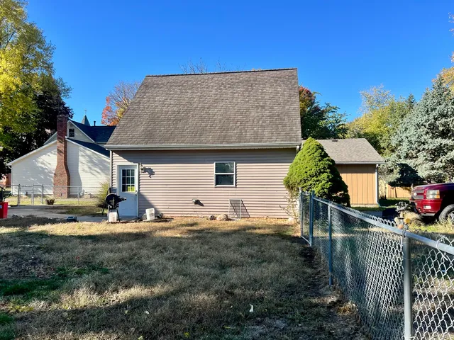 a view of a house with backyard and trees
