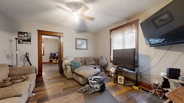 a living room with furniture a flat screen tv and a window