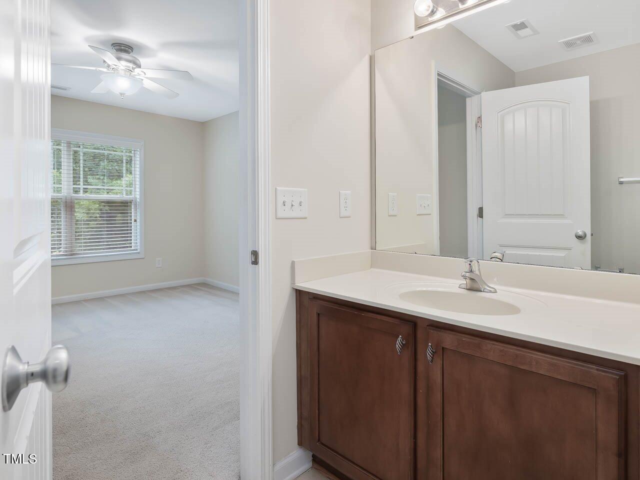 4719 Altha Street Raleigh, NC 27606 - Photo 17 of 19 a bathroom with a sink vanity and a mirror