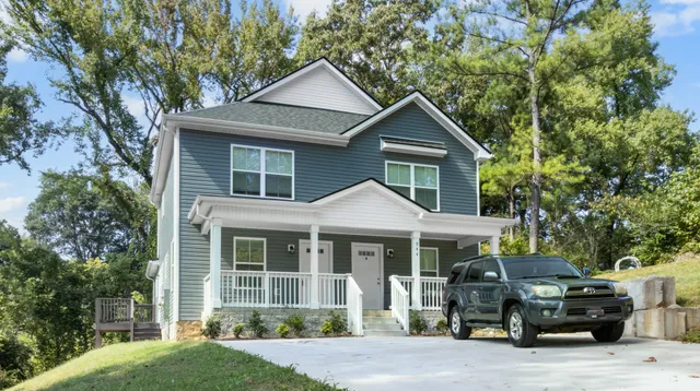 a front view of a house with cars parked