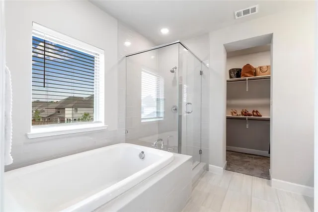 a bathroom with a tub a sink and a window