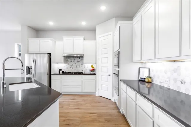 a kitchen with kitchen island granite countertop a sink appliances cabinets and counter space